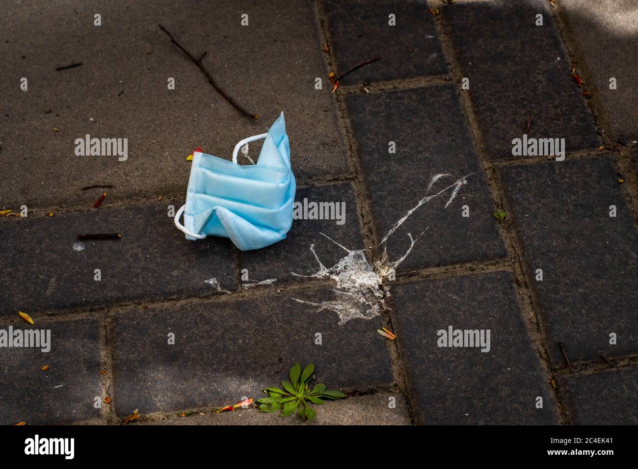 La fin du coronavirus. Arrêtez Covid 19. Les gens se défausser du masque facial de protection chirurgical dans les rues publiques. Masque médical sale posé sur le sol Banque D'Images