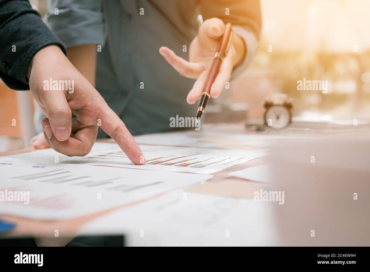 Gros plan sur l'analyse de groupe de jeunes gens d'affaires vers le graphique papier de données sur le bureau dans l'espace de travail. Banque D'Images