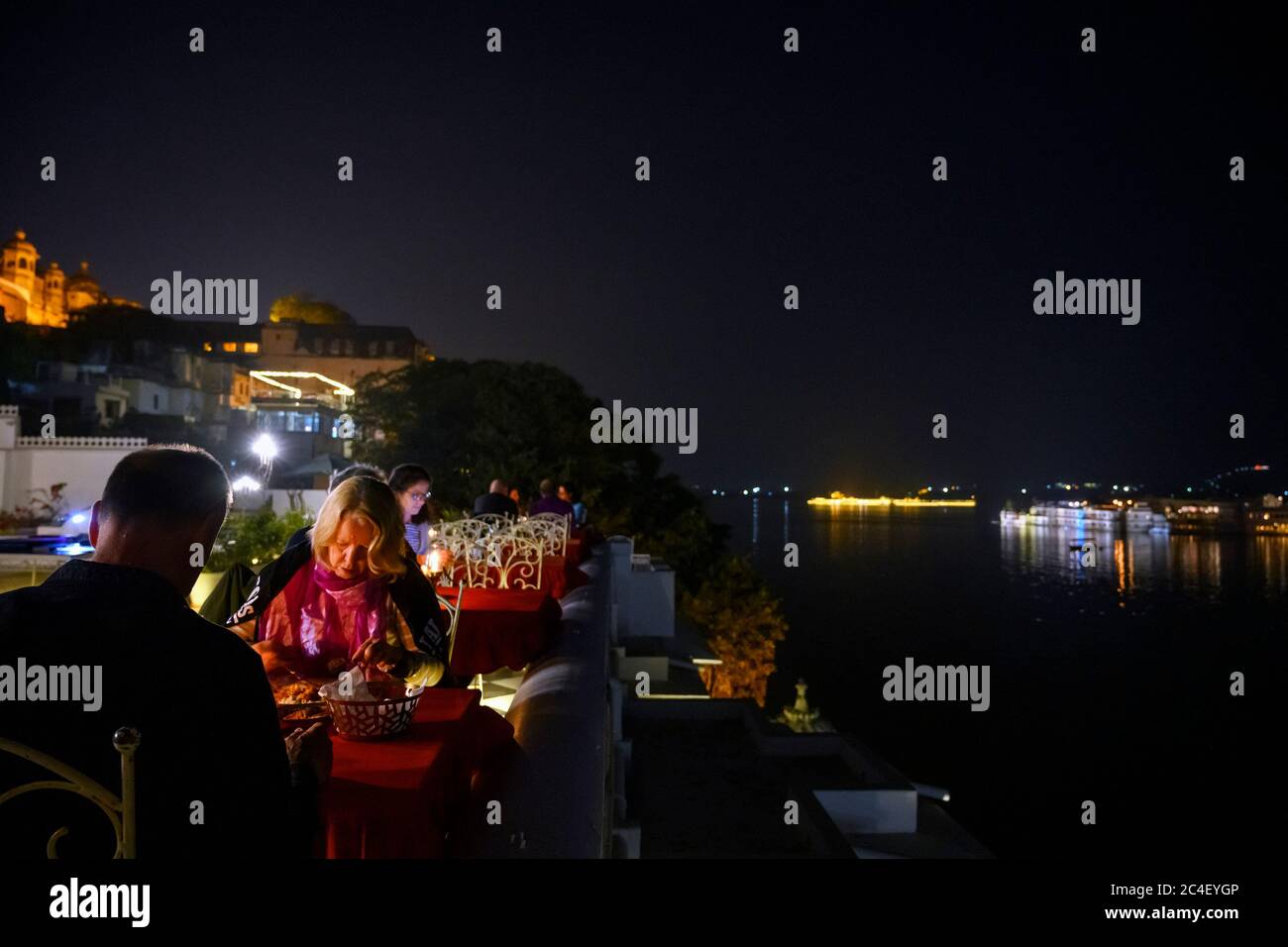 Terrasse de restaurant la nuit dans l'hôtel Jagat Niwas Palace avec une vue sur le lac Pichola, la vieille ville, Udaipur, Rajasthan, Inde Banque D'Images