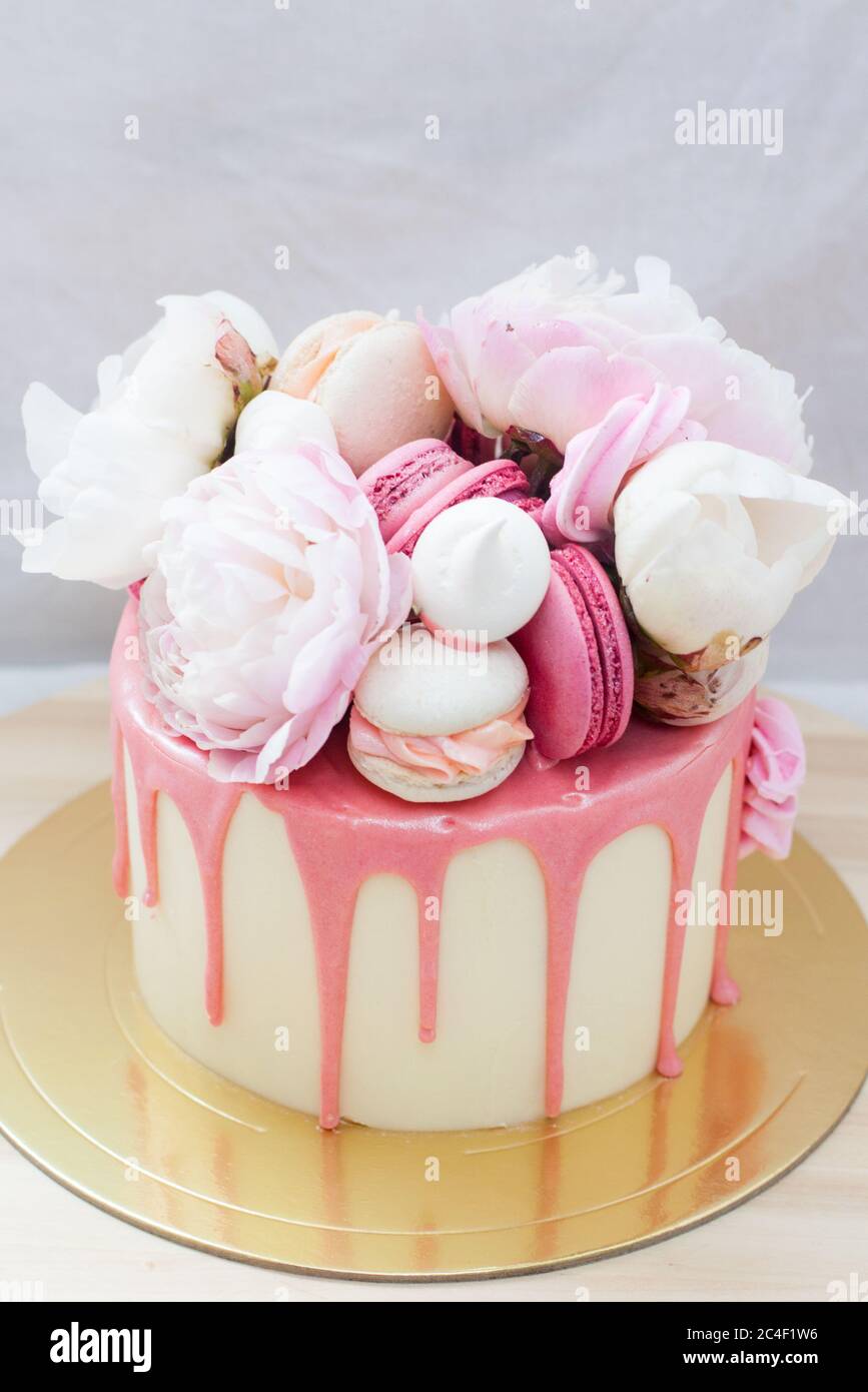 Petit Gateau D Anniversaire Avec Chocolat Rose Fondu Fleurs Fraiches Macarons Et Meringues Sur Fond Blanc Photo Stock Alamy