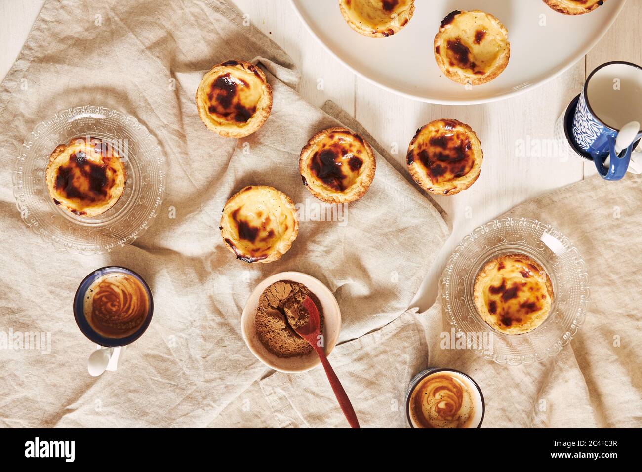 Vue de dessus de délicieux tartes aux œufs portugais avec une tasse d'espresso sur une table blanche Banque D'Images