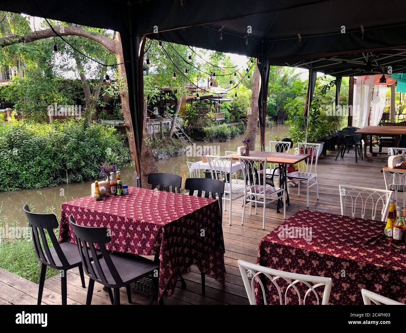 Tables et chaises de café à l'extérieur avec fond tropical local. Banque D'Images