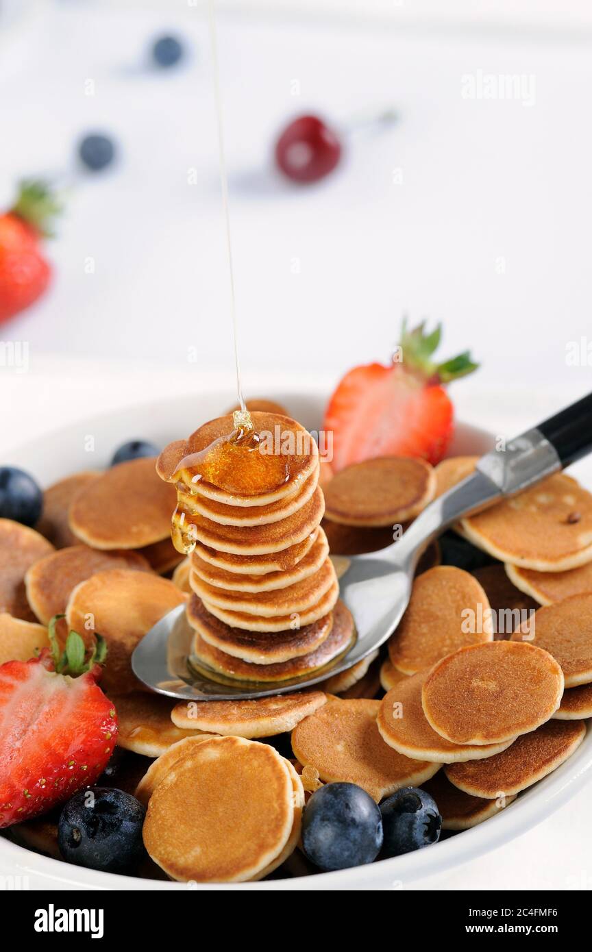 Petit déjeuner savoureux avec mini céréales pancakes avec fraises et bleuets. Mini céréales pancake est une nouvelle cuisine tendance pour les activités. Banque D'Images