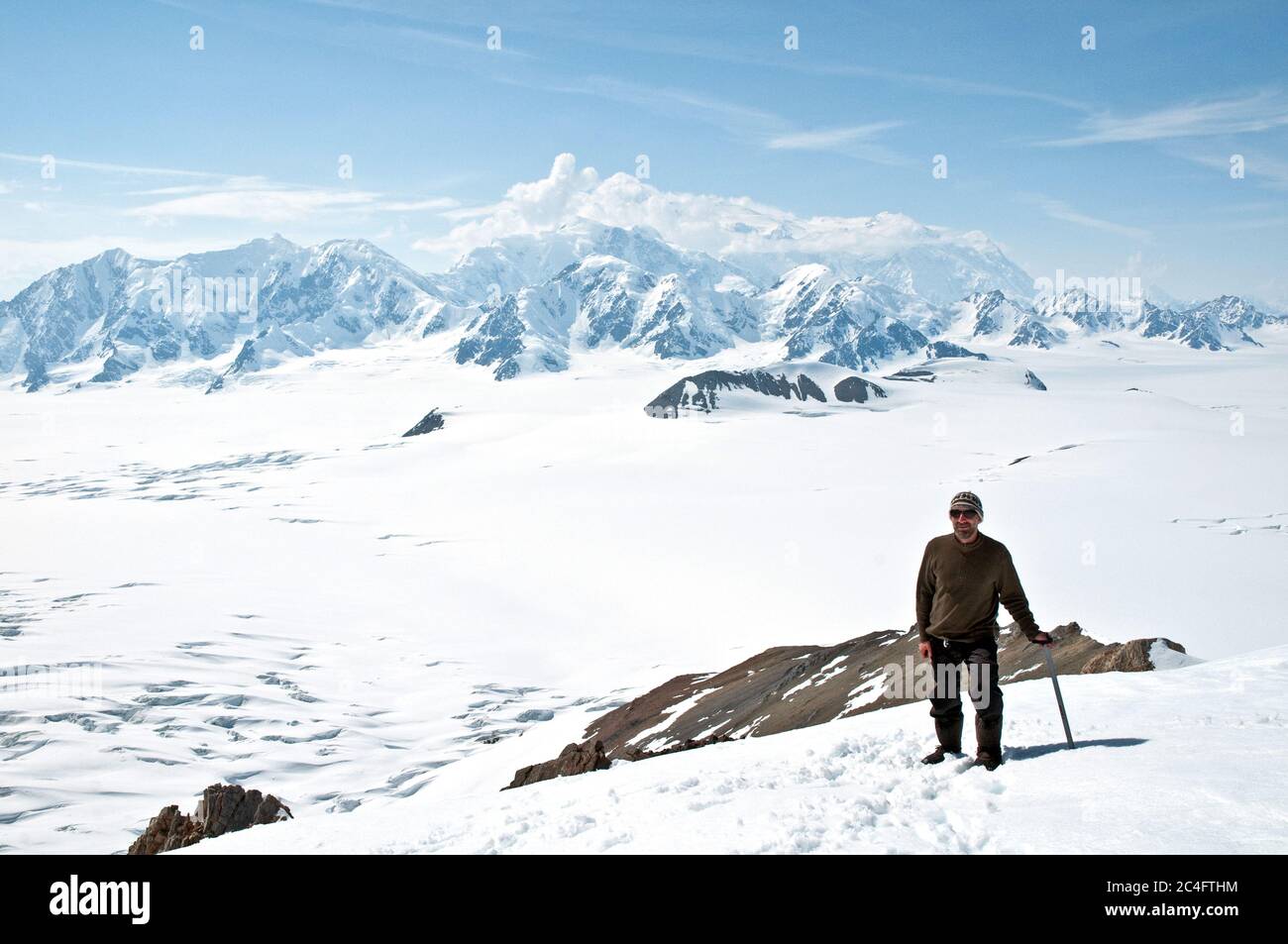 Un alpiniste tenant une hache de glace surplombe le mont Logan, le plus haut sommet du Canada, dans les champs de glace des monts St. Elias, territoire du Yukon, Canada. Banque D'Images