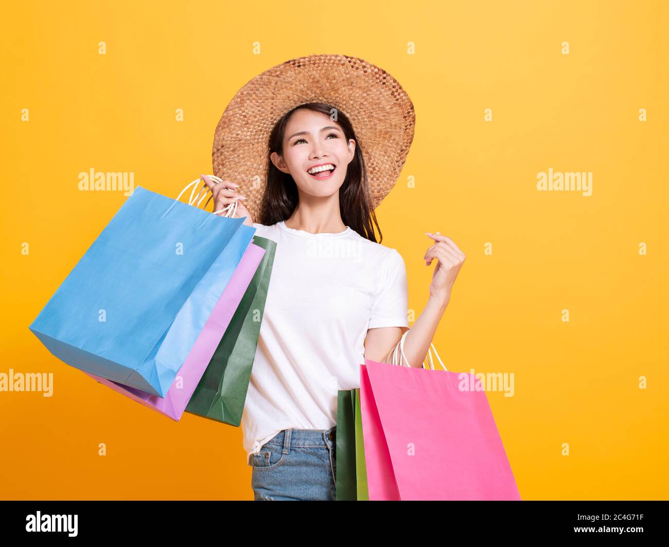 jeune femme en chapeau d'été et en tenant des sacs de shopping Banque D'Images