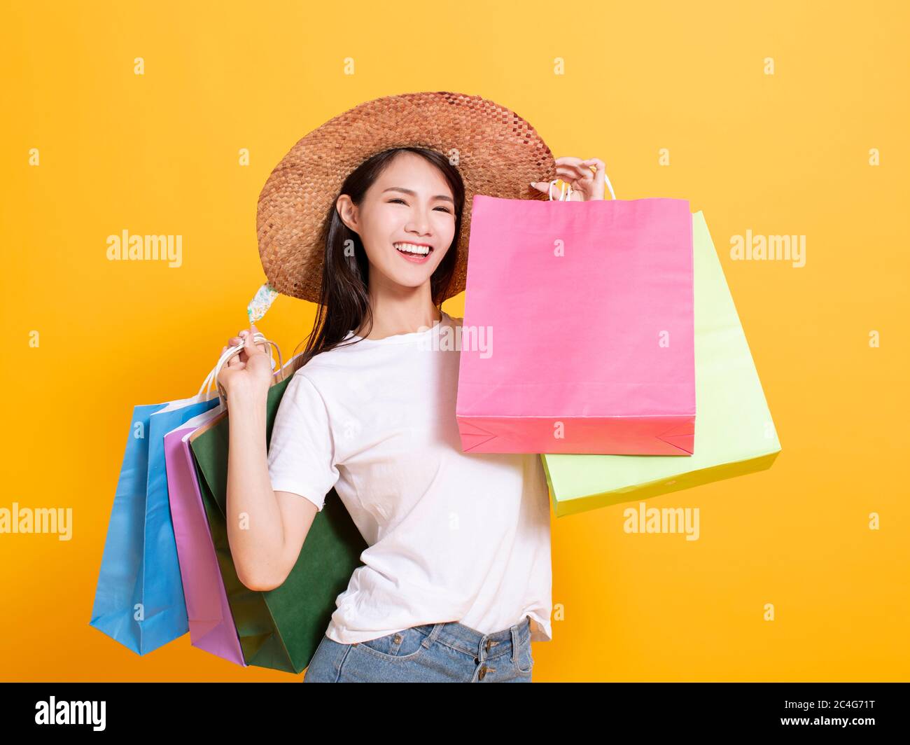 jeune femme en chapeau d'été et en tenant des sacs de shopping Banque D'Images