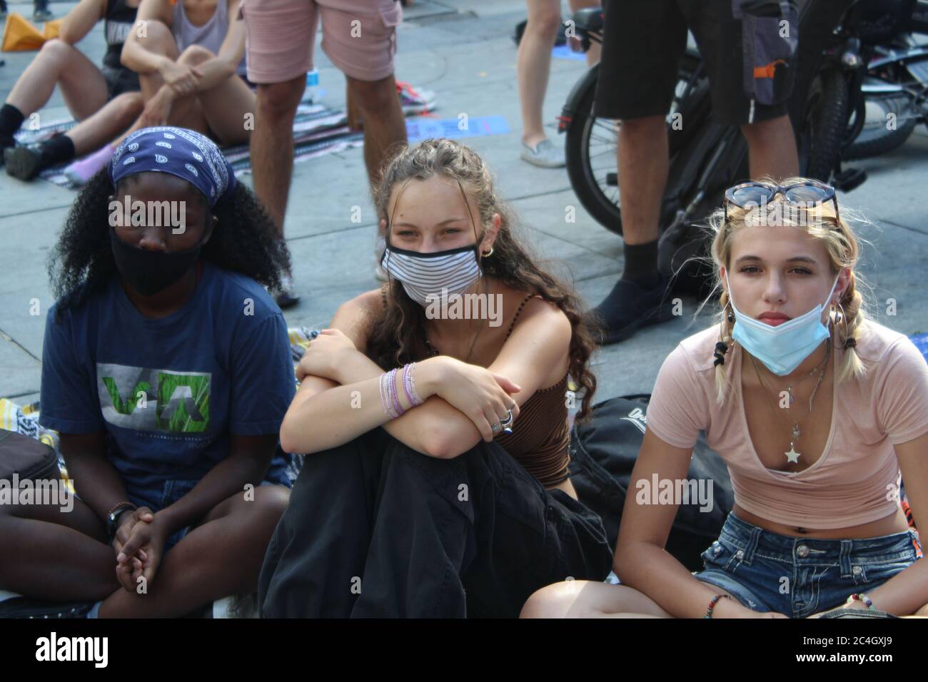 New York, New York, États-Unis. 25 juin 2020. Après des semaines de manifestations contre la brutalité policière et l'injustice raciale, les manifestants de New York campent devant l'hôtel de ville pour exiger une réduction de 1 milliard de dollars du financement du NYPD avant la date limite du budget du 1er juillet. Ces 3 jeunes filles aux visages masqués sont assises dans l'espace public à l'écoute des témoignages de violence policière. Les défenseurs de la réforme de la police affirment que le budget de la police de la ville, qui représente près de 6 milliards de dollars, doit être considérablement réduit et réinvesti dans le logement, les soins de santé et d'autres services sociaux. Crédit : Marie le BLE/ZUMA Wire/Alay Live News Banque D'Images