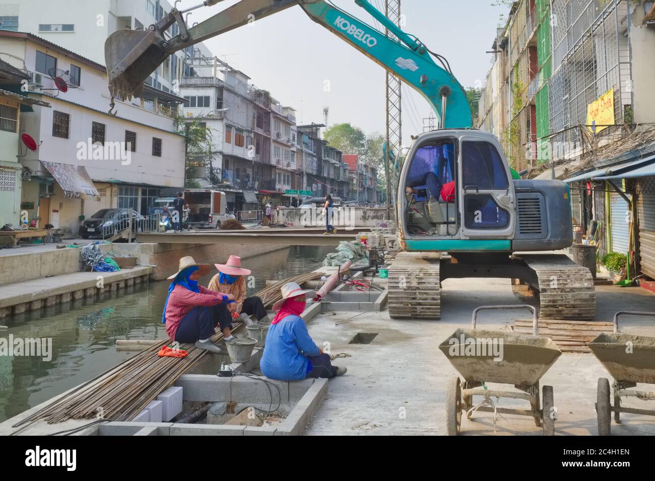 Travaux de rénovation avec des ouvriers de construction de pelles hydrauliques et de femmes à Klong ROP Krung (Klong Ong Ang); dans Chinatown / zone de Phahunat, Bangkok, Thaïlande Banque D'Images