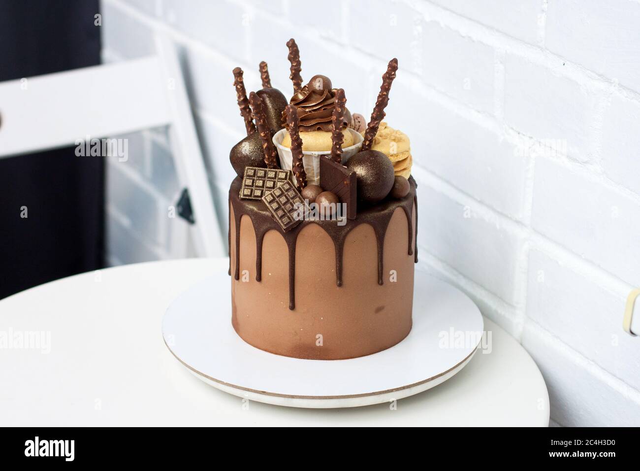 Gâteau d'anniversaire au chocolat élégant avec chocolat noir fondu, gâteau, gâteau, biscuits et bonbons sur fond blanc. Banque D'Images