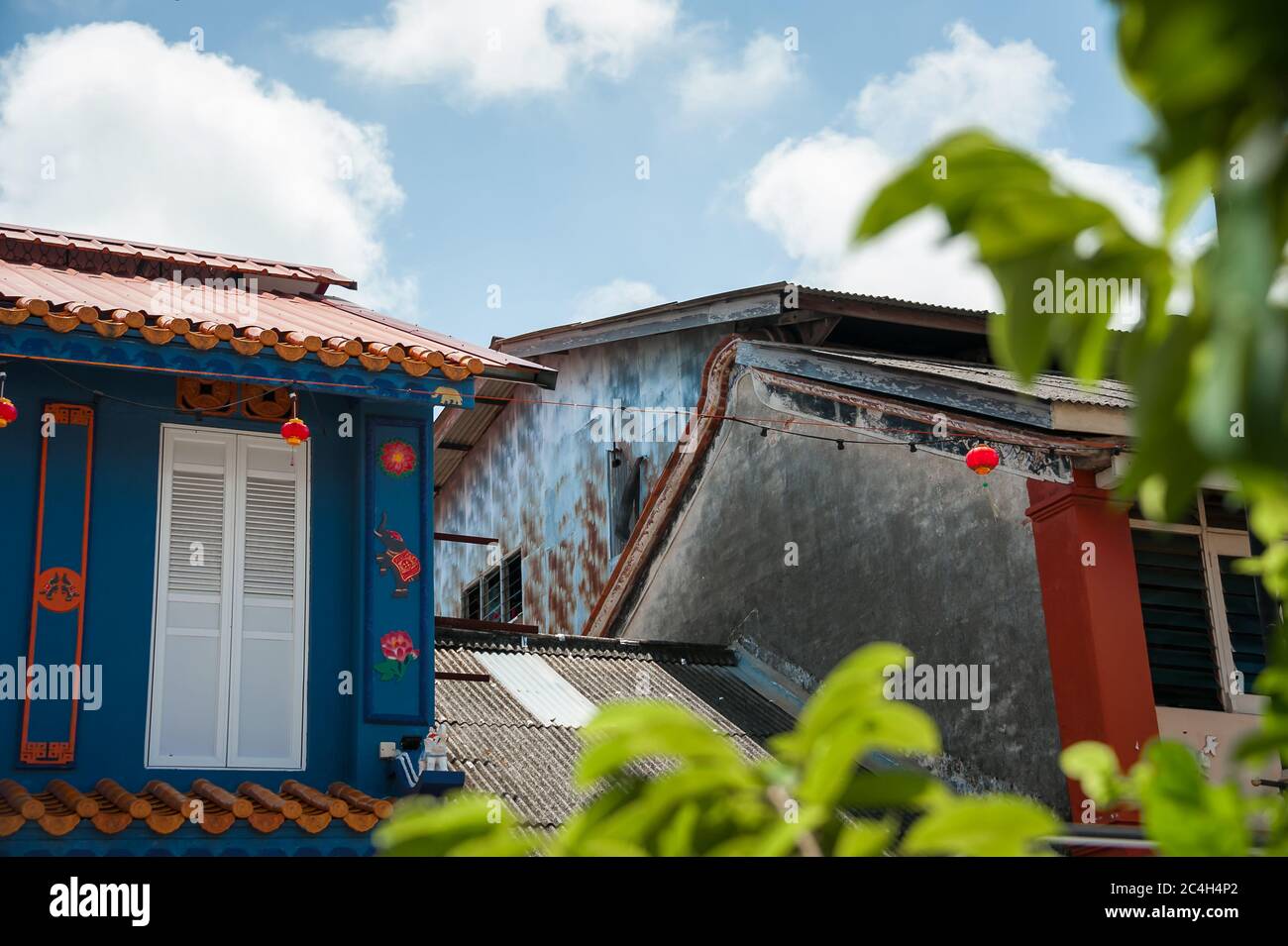 Rues colorées de Chinatown (Kampung Cina), site important du patrimoine de Terengganu, vue aux magasins, avec fond bleu, ciel nuageux Banque D'Images