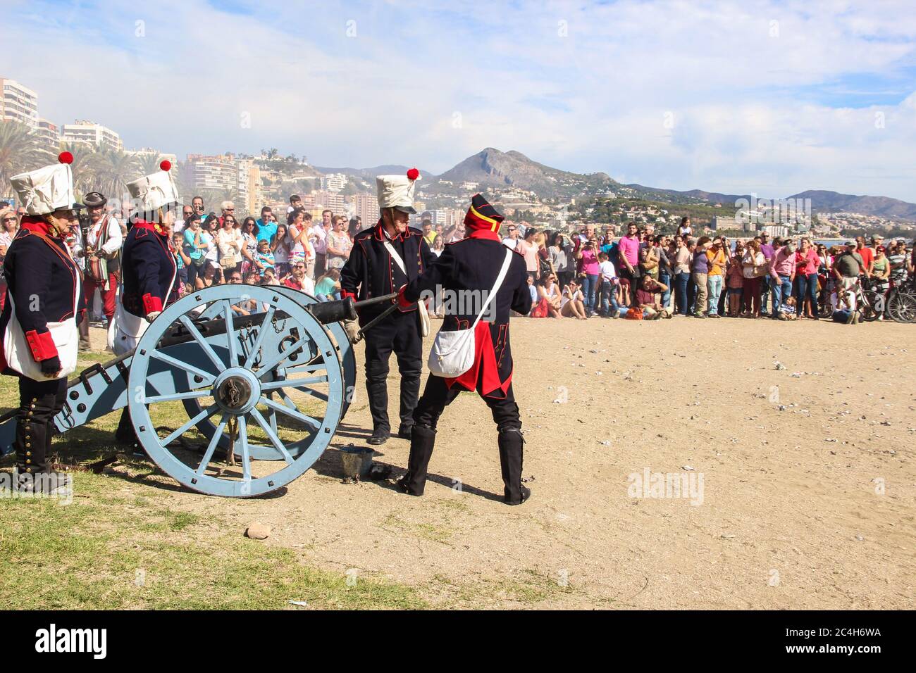 Malaga, Espagne - 26 octobre 2014 : des soldats français du XVIIIe siècle chargent un canon de poudre. Les hommes et les femmes réacteurs. La foule attend. Hist Banque D'Images