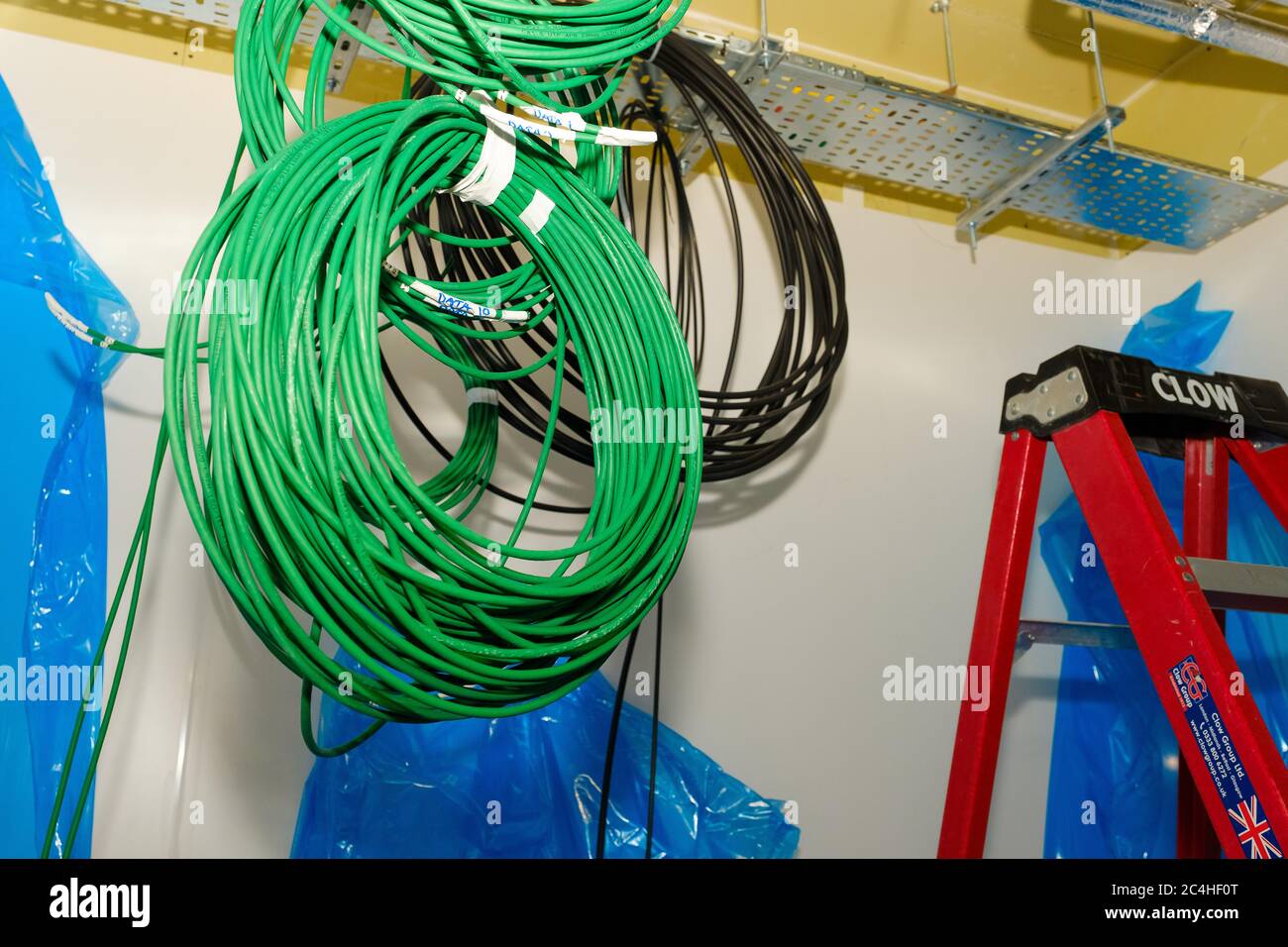 Les antennes du câble réseau pendent du plafond dans le bâtiment en construction Banque D'Images