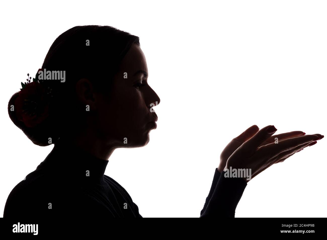 Une jeune femme montre ses mains en avant, envoyant un baiser - silhouette Banque D'Images
