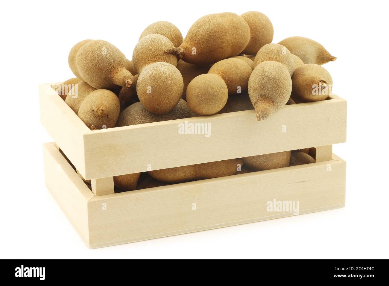 Haricots de Tamarind dans une boîte en bois sur fond blanc Banque D'Images