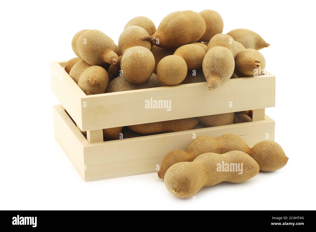 Haricots de Tamarind dans une boîte en bois sur fond blanc Banque D'Images