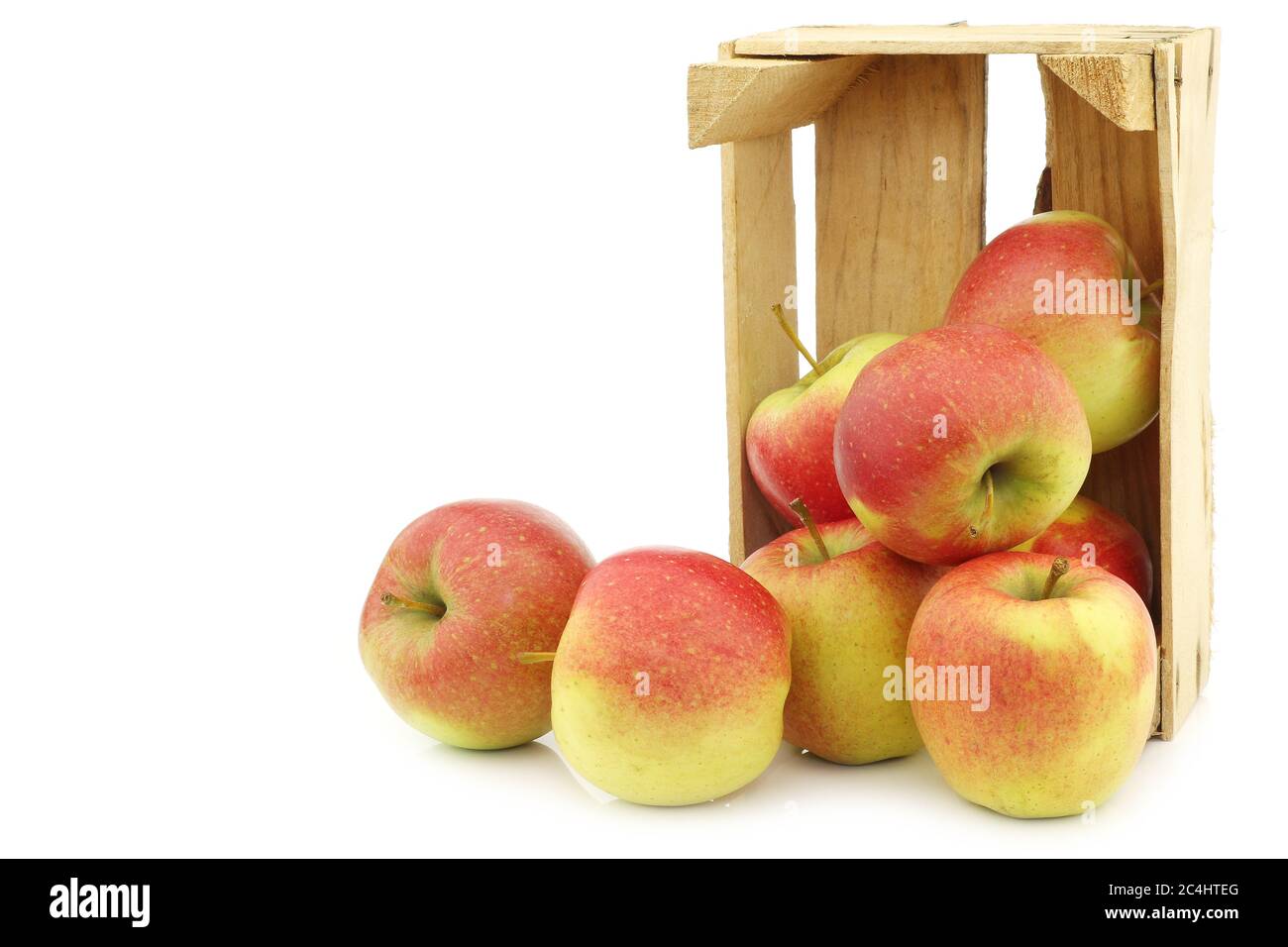 Pommes Maribelle fraîches dans une caisse en bois sur fond blanc Banque D'Images