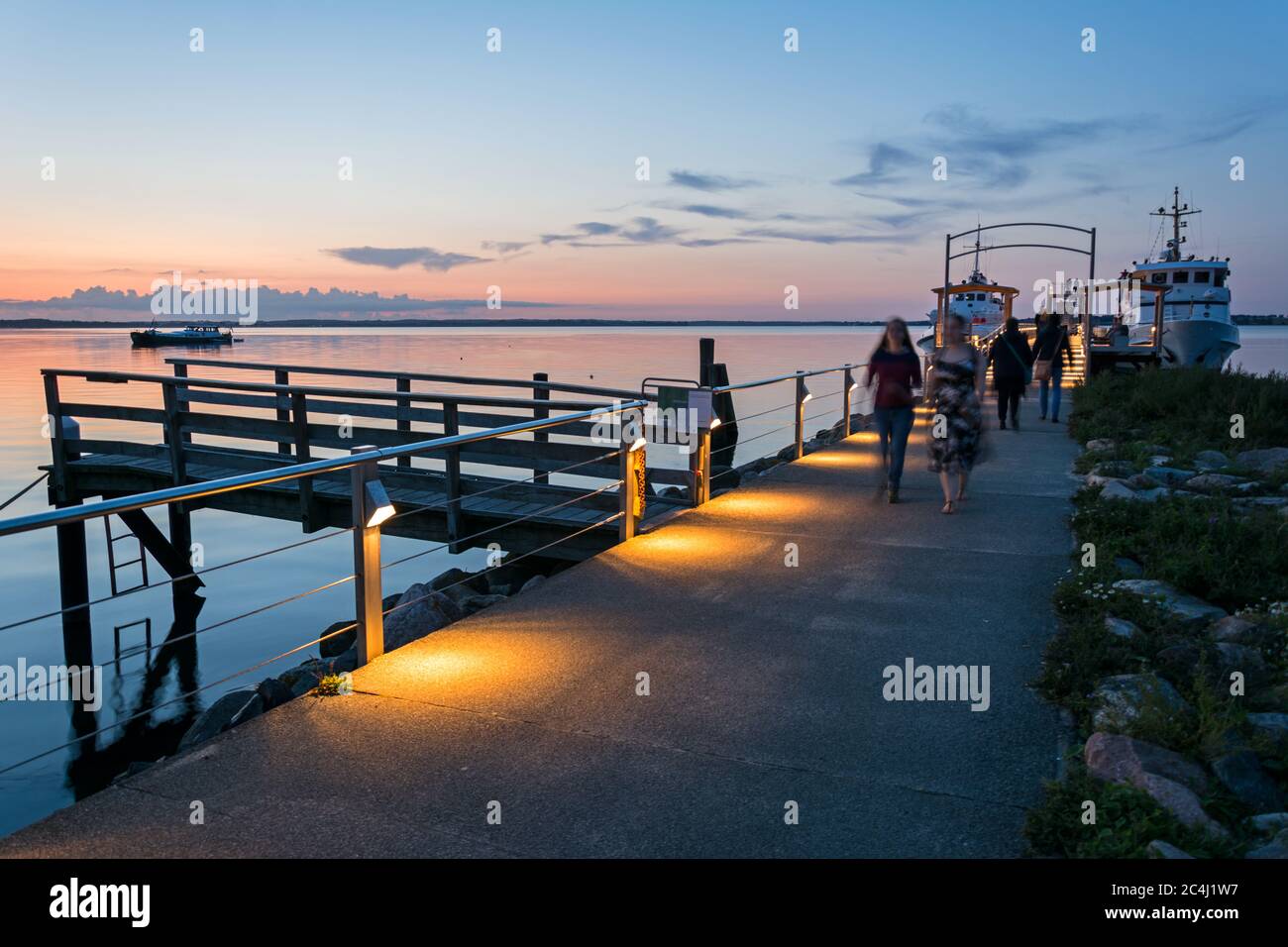 Promenade et ferry à la mer Baltique calme dans la lumière du soir Banque D'Images
