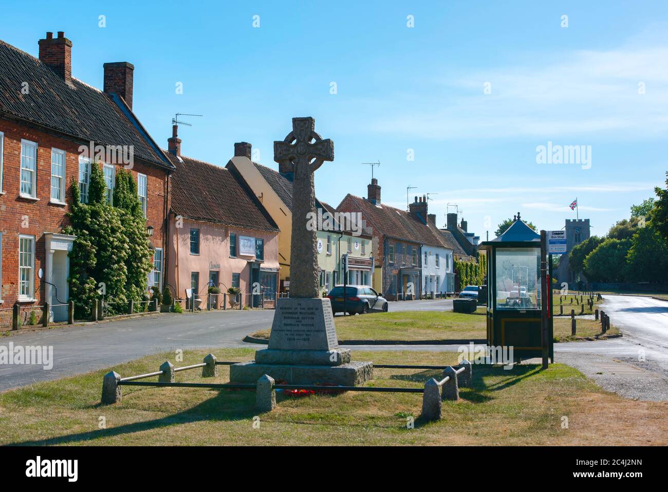 Burnham Market Norfolk, vue en été de la croix du mémorial de guerre et des magasins traditionnels et propriété sur le Green à Burnham Market, nord de Norfolk, Royaume-Uni. Banque D'Images