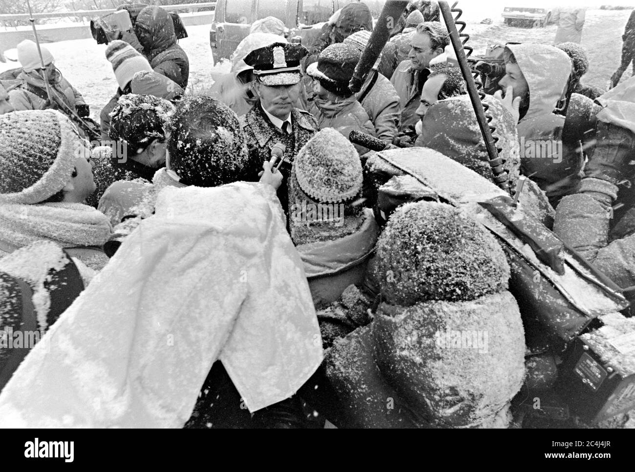 James Shugart, inspecteur de la police de D.C., au centre, brave une tempête de neige pour informer les médias sur les efforts de rétablissement et d'enquête du vol d'Air Florida 90 le 14 janvier 1982 à Washington, D.C., le vol passager américain s'est écrasé sur le fleuve Potomac après avoir heurté le pont de la 14e rue le 13 janvier 1982, tuant 74 personnes. Banque D'Images