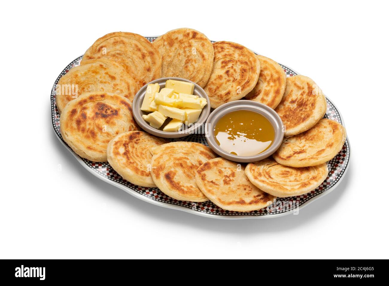 Meloui frais, crêpes marocaines au beurre et au miel sur une assiette isolée sur fond blanc Banque D'Images