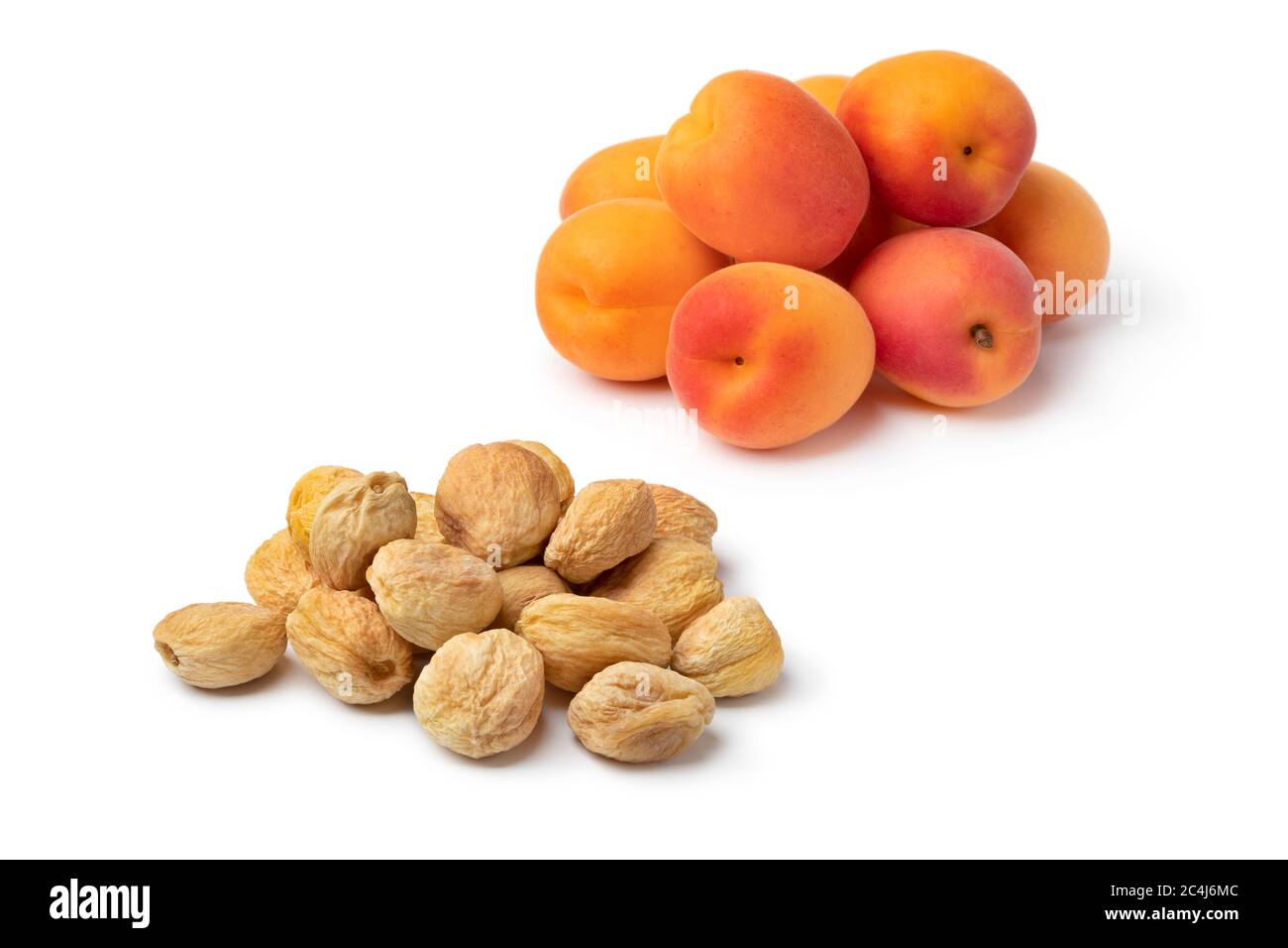 Tas d'abricots doux d'orange frais et séchés sans conservateurs isolés sur fond blanc Banque D'Images