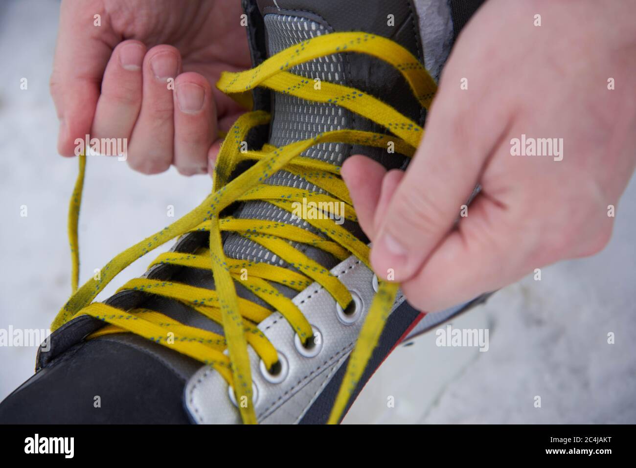 Un homme qui enferme des patins dans la neige en hiver, gros plan Banque D'Images