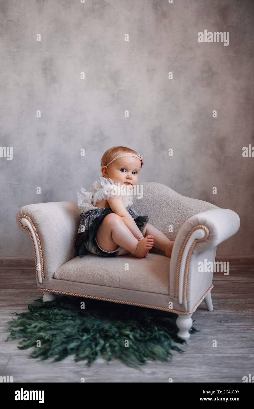 Bébé mignon sur le canapé. Bébé fille assis sur des meubles spéciaux de  petit bébé Photo Stock - Alamy