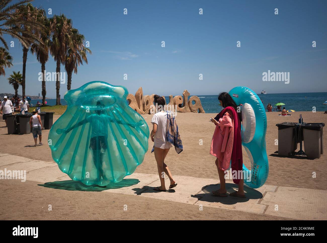 Les gens transportant des flotteurs à la plage de la Malagueta pendant une chaude journée d'été.UNE vague de chaleur traverse le pays avec des températures élevées, selon l'Agence espagnole de météorologie. Banque D'Images