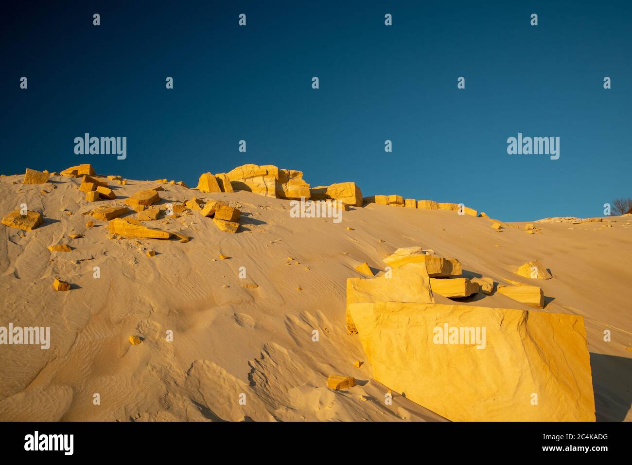 De grandes pierres dans le désert. Sable jaune sur fond de ciel bleu. Banque D'Images