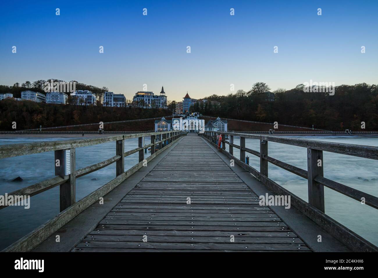 Jetée en bois de Sellin dans la soirée. Section côtière avec jetée sans éclairage avec vue sur la ville et les bâtiments. La mer Baltique en automne Banque D'Images