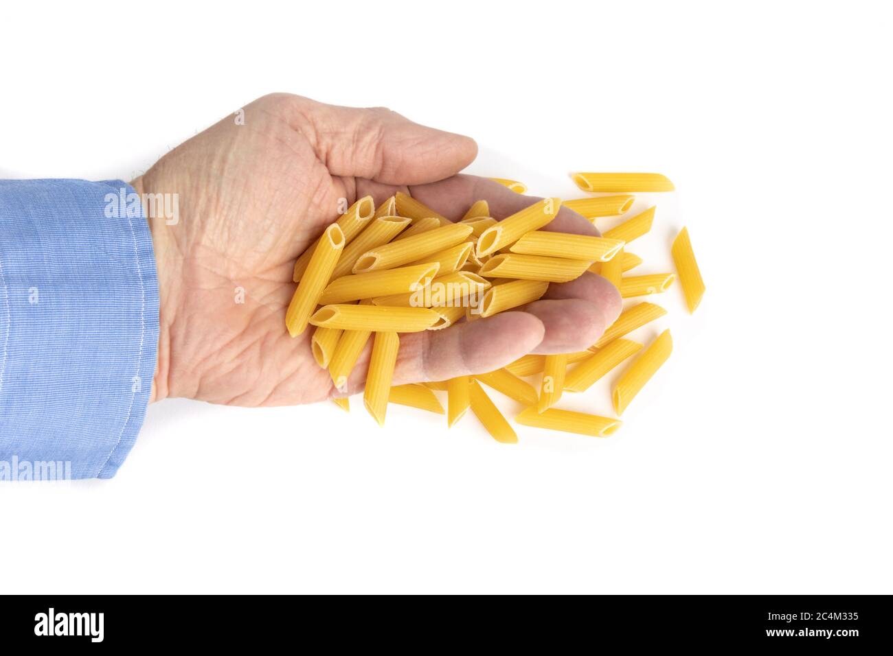 un cuisinier mâle avec une main pleine de pâtes de penne rigate isolées sur blanc Banque D'Images