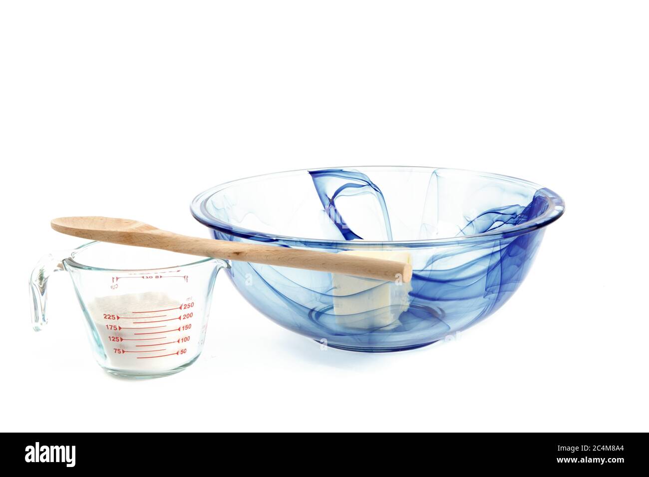un bol à mélanger en verre bleu avec du beurre et une tasse de farine  graduée isolée sur blanc Photo Stock - Alamy
