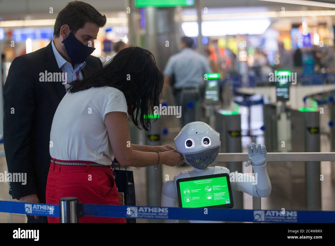 Athènes, Grèce. 26 juin 2020. Les membres du personnel de l'aéroport international d'Athènes placent un masque facial sur un robot Pepper à Athènes, Grèce, le 26 juin 2020. POUR ALLER AVEC: 'Feature: L'aéroport international d'Athènes recrute des robots pour informer les voyageurs sur les mesures COVID-19' Credit: Marios Lolos/Xinhua/Alay Live News Banque D'Images