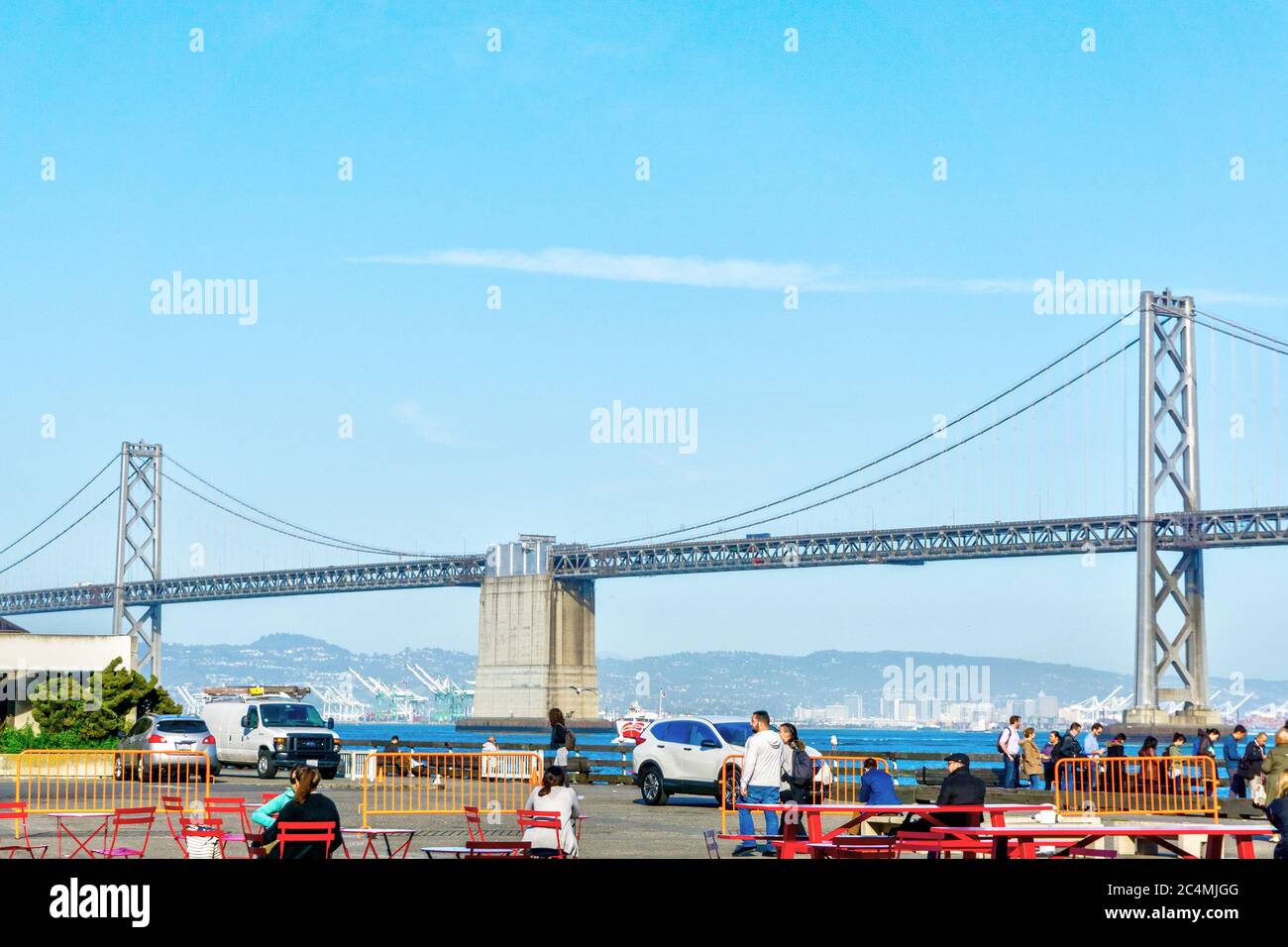 SAN FRANCISCO - 2 AVRIL 2018 : la foule se mêle à l'extérieur de la jetée de San Francisco avec le pont de la baie d'Oakland en arrière-plan. Banque D'Images