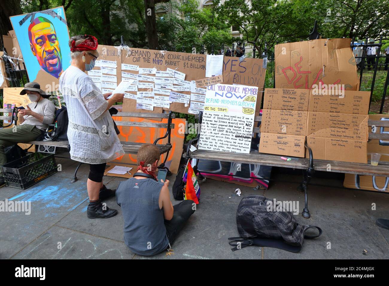 New York, NY 26 juin 2020. Les gens d'un poste d'action législative à l'hôtel de ville d'Occupy avec des panneaux indiquant comment communiquer avec les membres du Conseil de la ville de New York pour exiger qu'ils réduisent le budget de NYPD de 1 milliard de dollars. Activistes avec voix avec activistes et leaders communautaires (vocal NY) Et les alliés ont occupé un parc adjacent à l'hôtel de ville avant la date limite du 1er juillet pour exercer des pressions directes sur le maire et le conseil municipal pour qu'ils définancent le NYPD d'au moins 1 milliard de dollars de leur budget annuel de 6 milliards de dollars pour réinvestir dans le logement, les soins de santé, l'éducation et les services sociaux. Banque D'Images