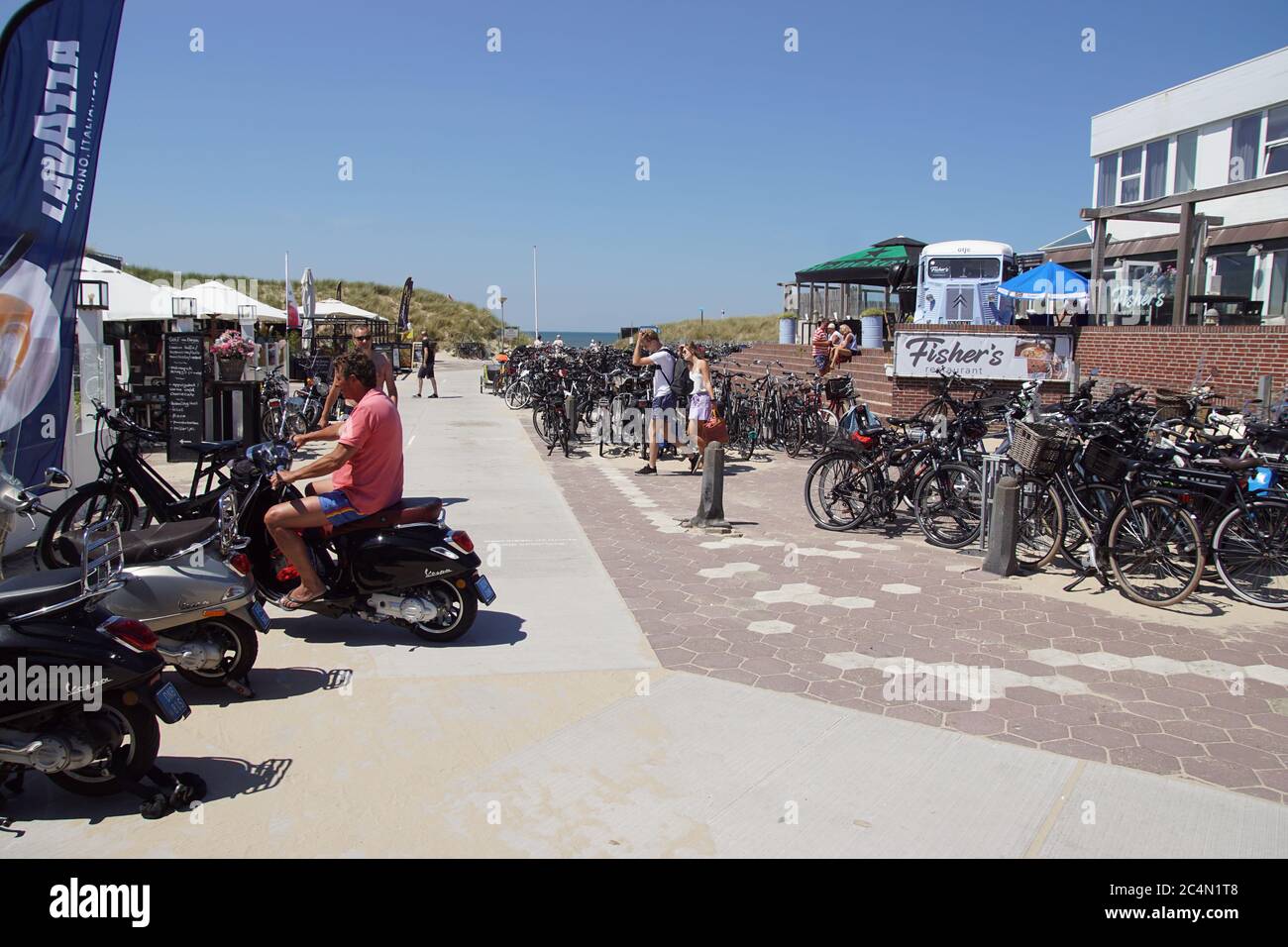 Entrée à la plage du village côtier néerlandais de Bergen aan Zee avec de nombreux vélos et scooters. Juin, une belle journée d'été aux pays-Bas. Banque D'Images