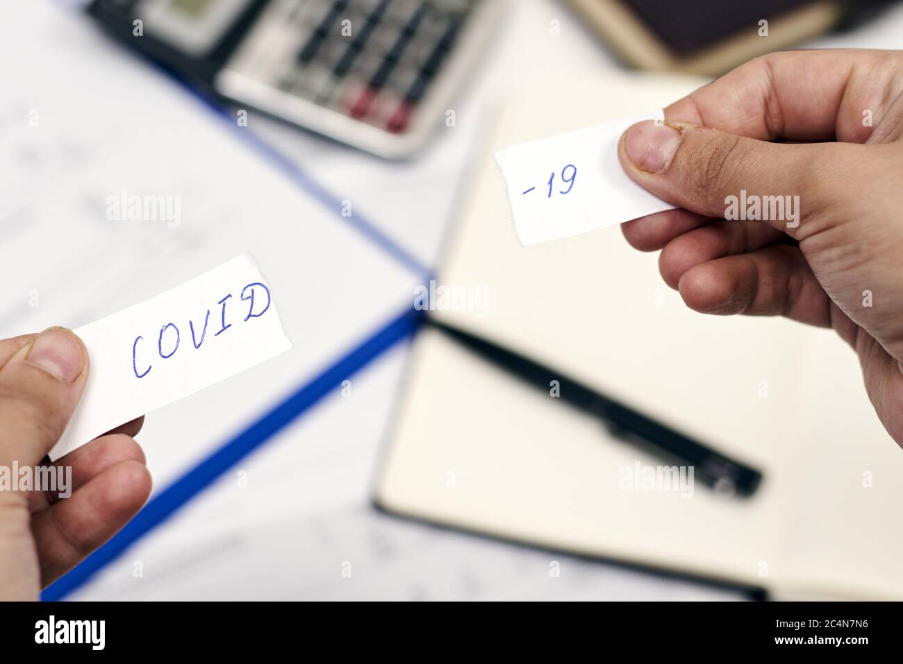 Homme tenant un morceau de papier déchiré avec le mot 'COVID-19' dessus. Surmonter le concept COVID-19 Banque D'Images