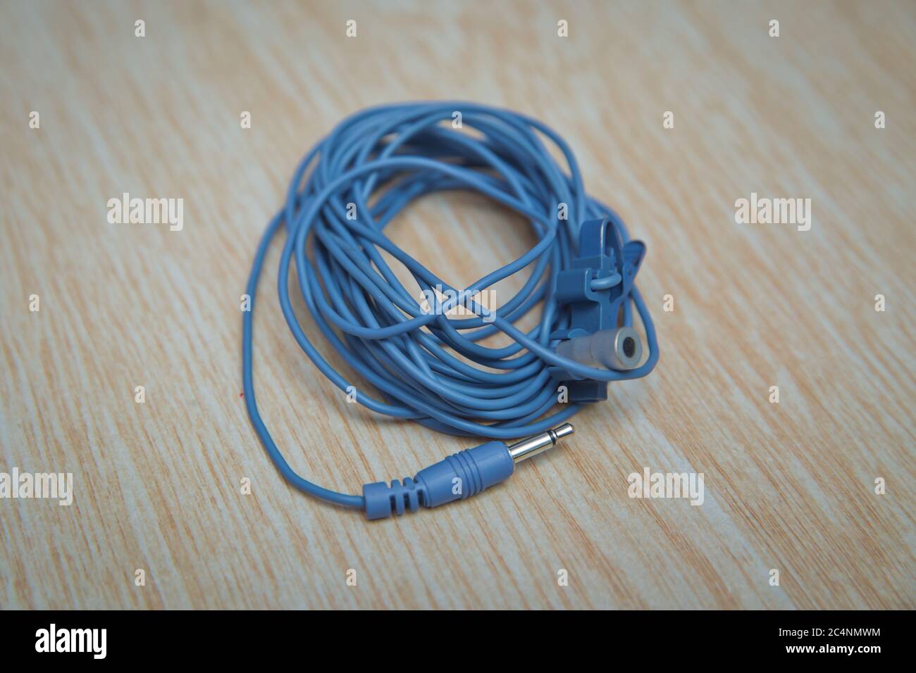 Câble de mini-jack audio pour microphone isolé sur fond en bois . Câble bleu de séparation pour microphone et casque . Banque D'Images