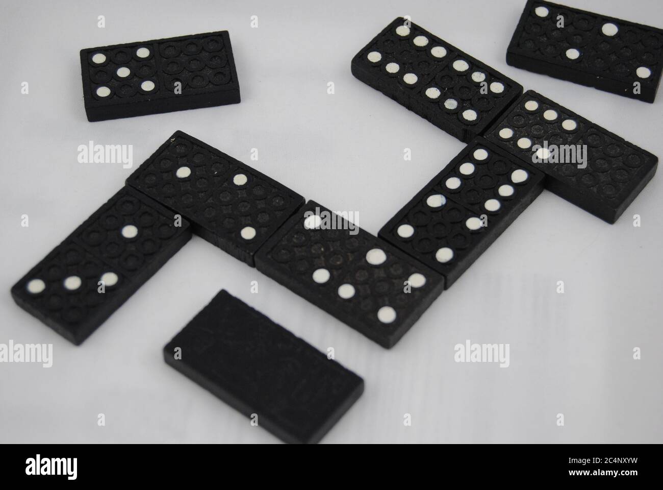 Gros plan de dominos noirs sur une surface blanche Banque D'Images