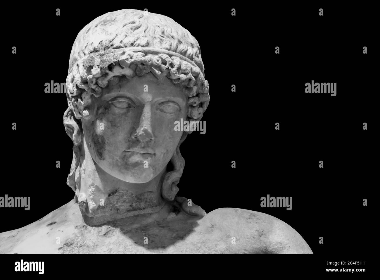 Photo en noir et blanc en gros plan de la tête de l'ancien sculpture en marbre romain d'un jeune homme avec une longueur de courbure cheveux Banque D'Images