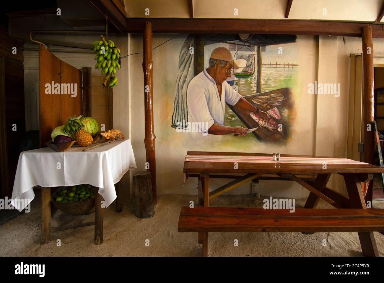 Table aux fruits et peinture à l'atmosphère typiquement bélizienne à l'intérieur du restaurant El Fogon, San Pedro, Ambergris Caye, Belize Banque D'Images