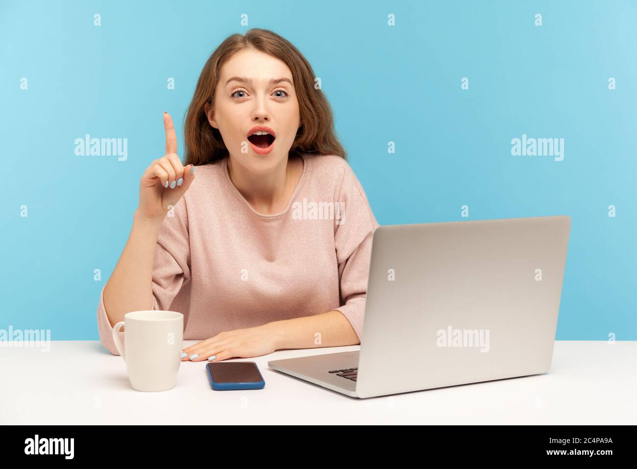 Excellente solution d'affaires ! Une jeune femme d'affaires excitée qui semble surprise par une idée de génie, se levant le doigt, inspirée par la pensée créative sur le lieu de travail Banque D'Images