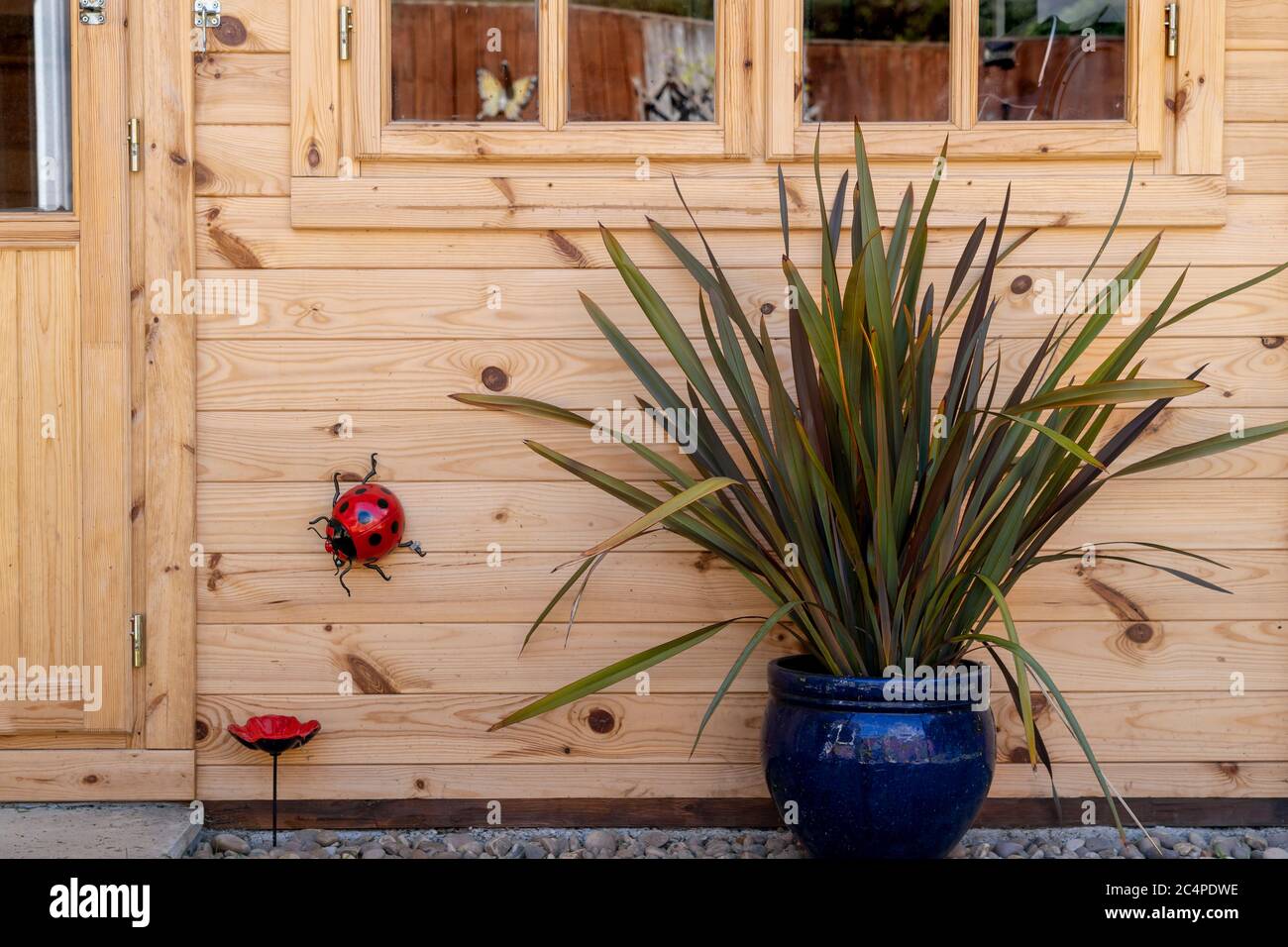 MAISON D'ÉTÉ OU CABANE EN RONDINS AVEC INSECTES DÉCORATIFS ET PLANTES ORNEMENTALES Banque D'Images