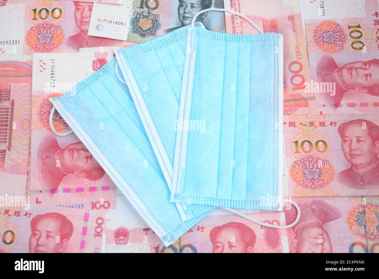 Masques jetables médicaux de Chine avec de l'argent chinois, yuan. Billets en RMB comme arrière-plan. Banque D'Images