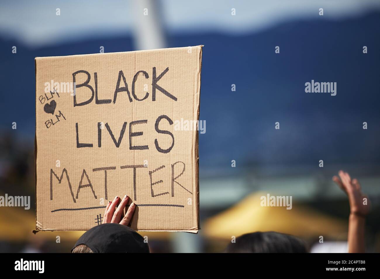 Une main tenant une pancarte en carton par une journée ensoleillée, isolée,  « la vie noire est importante » au rallye. Activisme au Canada,  rassemblement pour arrêter de tuer les Noirs Photo