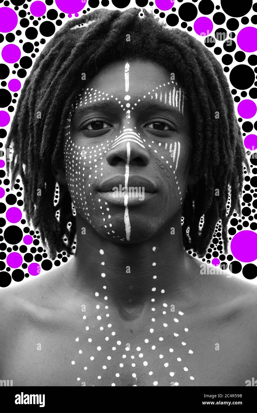 Portrait d'un jeune homme africain avec des dreadlocks et une peinture traditionnelle du visage regardant directement dans l'appareil photo Banque D'Images
