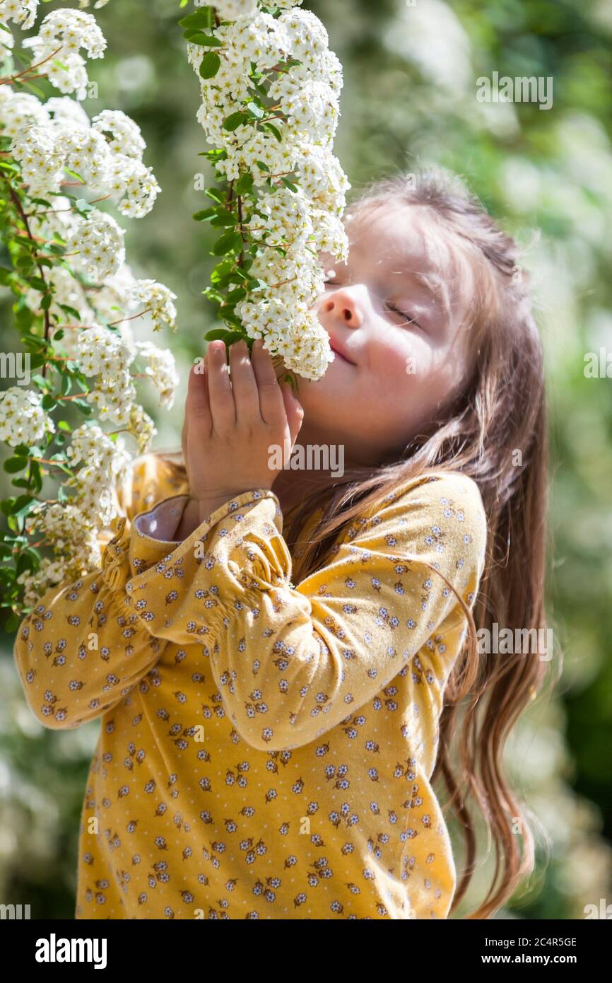 portrait d'une petite fille heureuse de quatre ans avec fleurs blanches Banque D'Images