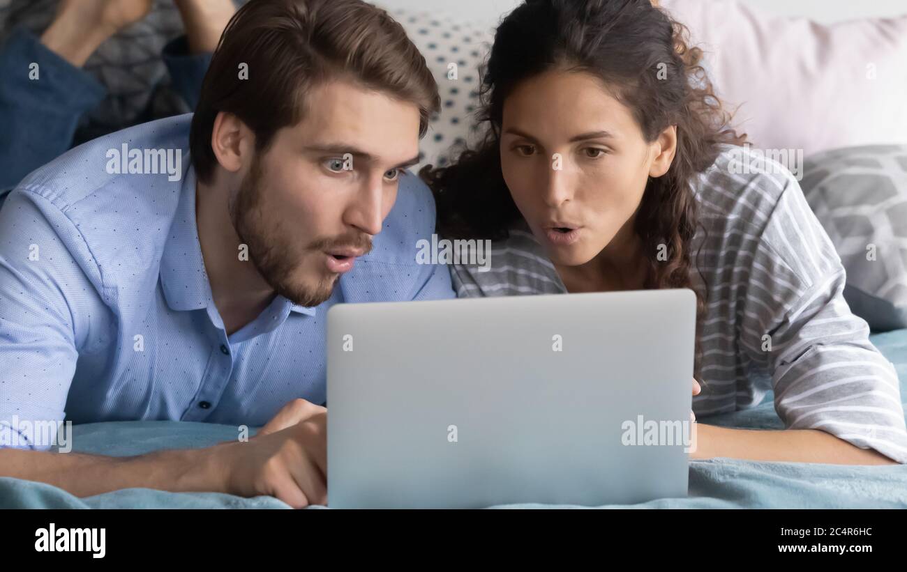 Jeune homme et femme intéressés regardant l'écran d'ordinateur portable ensemble Banque D'Images