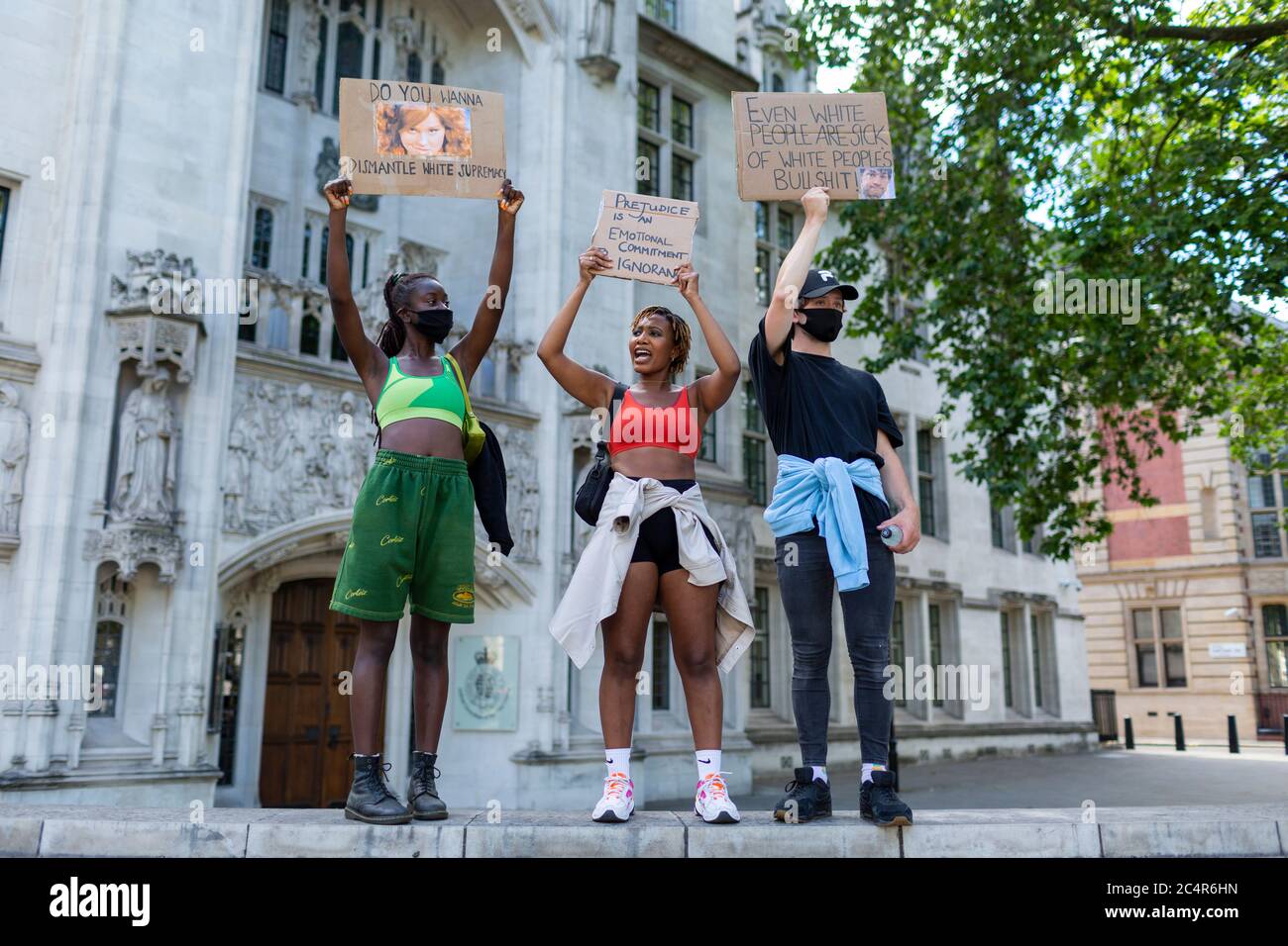 Trois manifestants se tiennent sur un mur tenant des panneaux lors d'une manifestation sur le thème de la vie noire, Parliament Square, Londres, 20 juin 2020 Banque D'Images
