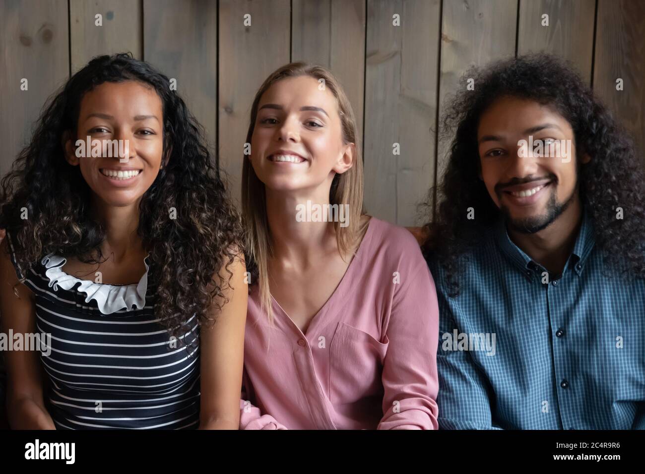 Groupe d'amis multiraciaux heureux souriant regardant l'appareil photo Banque D'Images